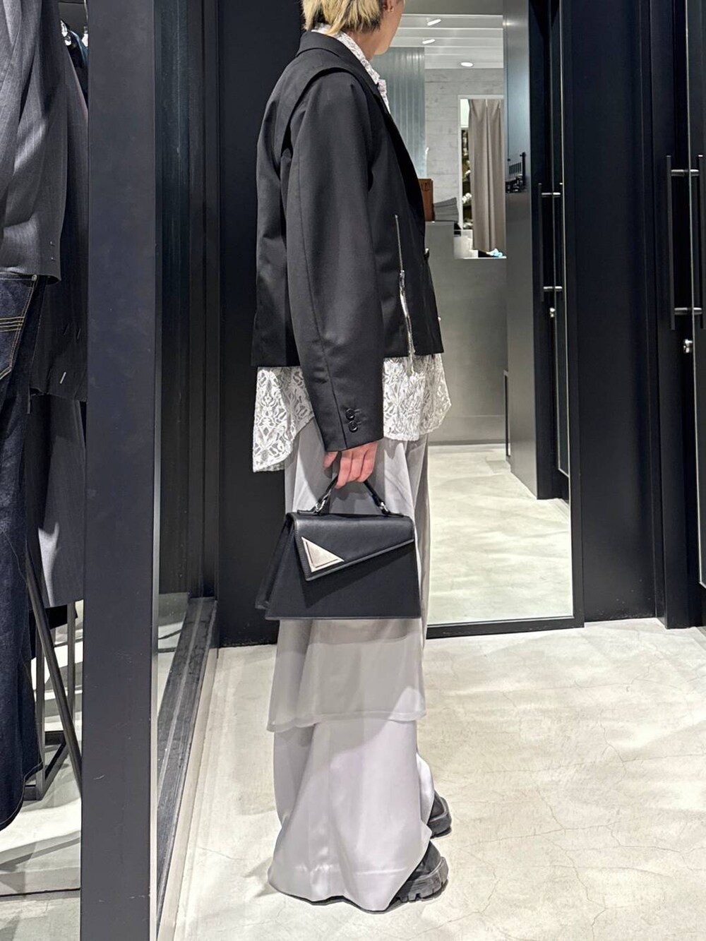 ブラック系のハンドバッグ、グレー系のTシャツ/カットソー、ブラック系のテーラードジャケットを着用したメンズの春コーディネートの2枚目の写真