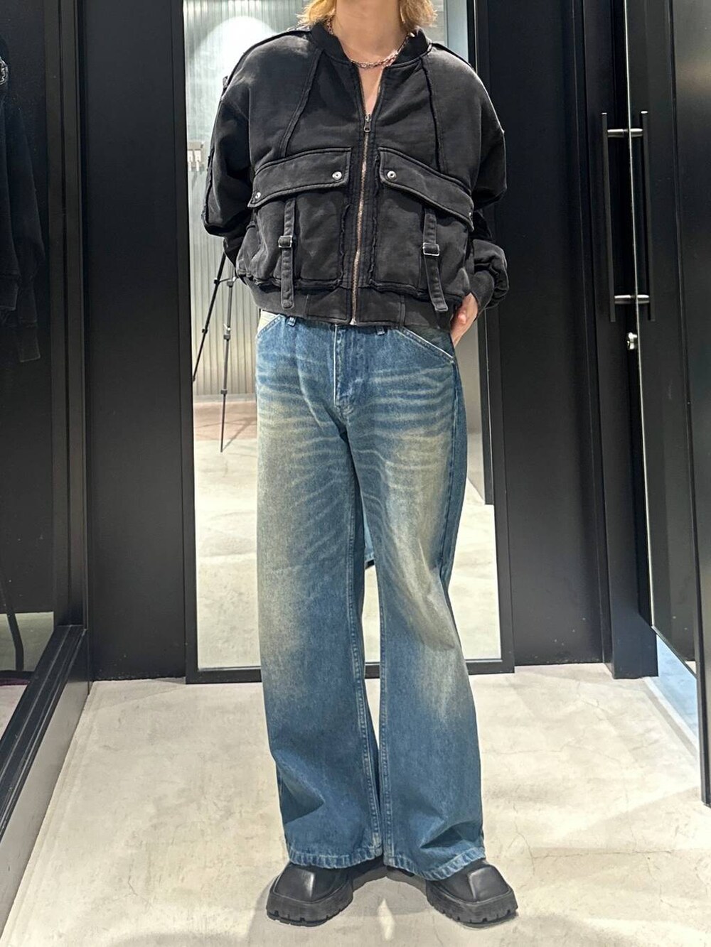 ブルー系のデニムパンツ、ブラック系のブルゾン、シルバー系のネックレスを着用したメンズの秋コーディネートの3枚目の写真