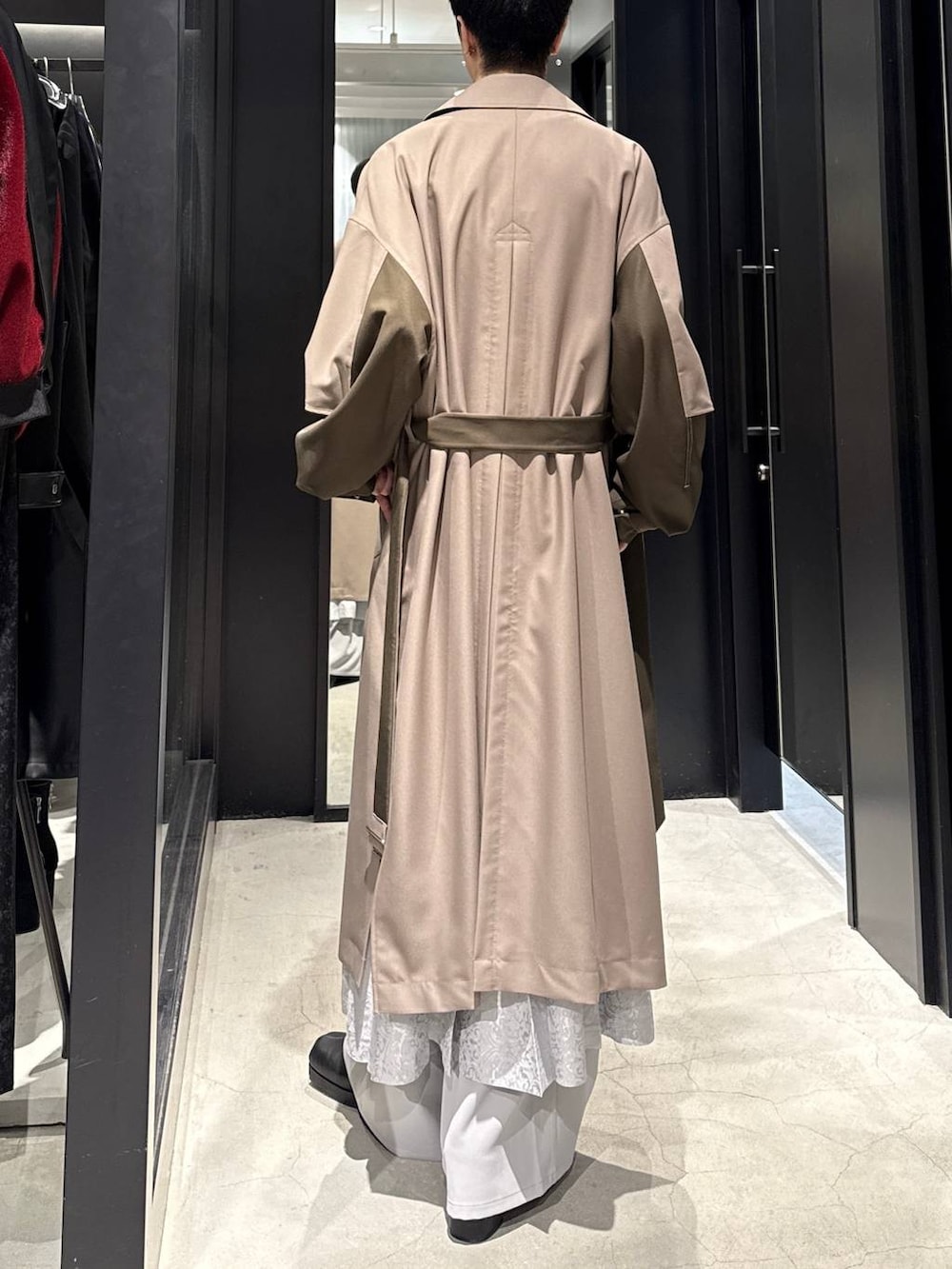 ブラック系のブーツ、ベージュ系のトレンチコート、グレー系のその他パンツを着用したメンズの冬コーディネートの3枚目の写真