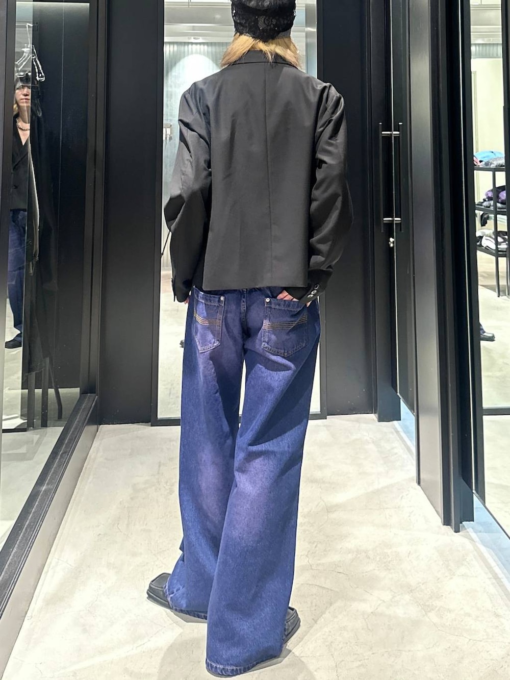 パープル系のデニムパンツ、ブラック系のテーラードジャケット、シルバー系のネックレスを着用したメンズの秋コーディネートの4枚目の写真