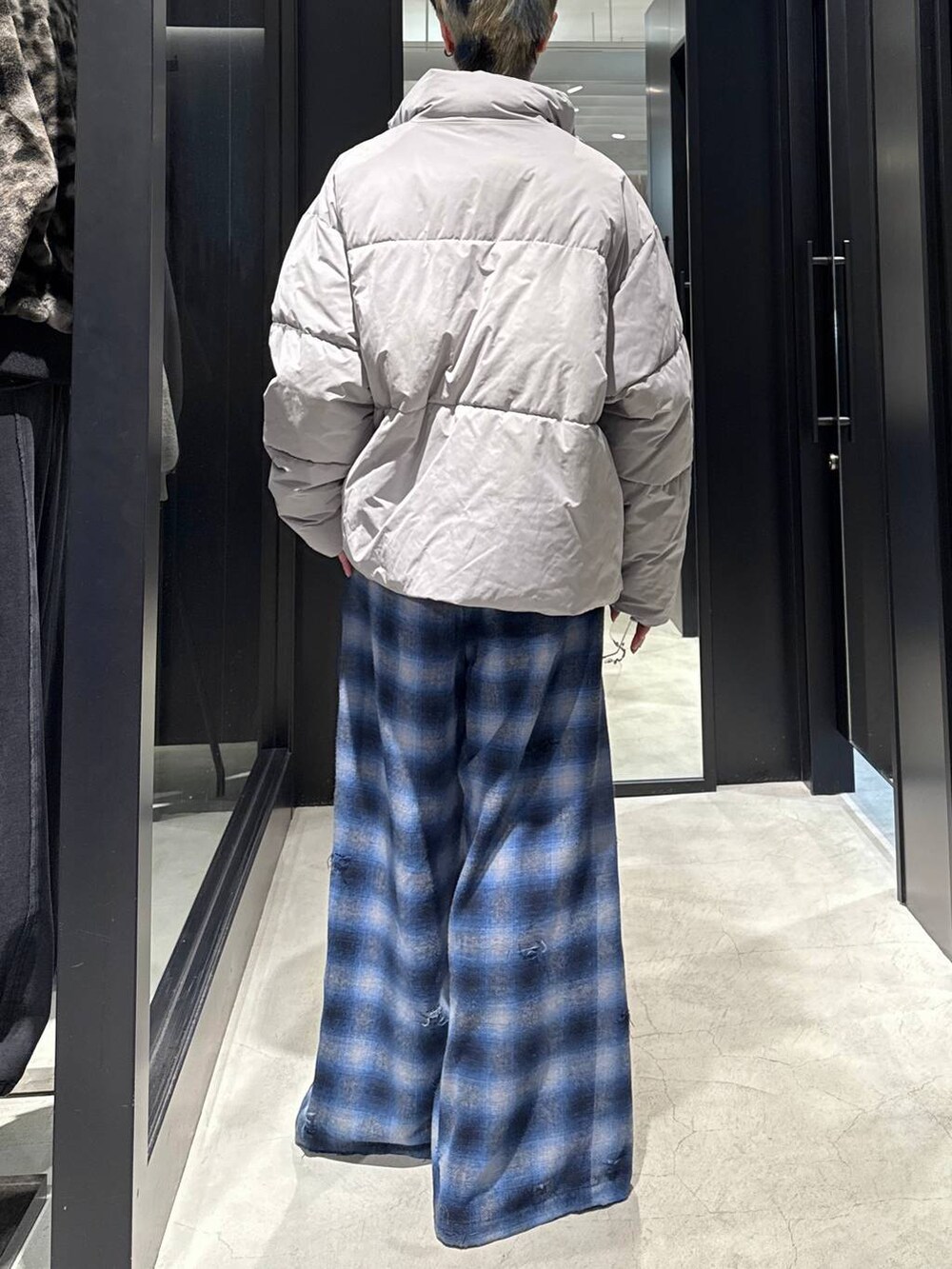 グレー系のブルゾン、ブルー系のその他パンツ、シルバー系のネックレスを着用したメンズの冬コーディネートの3枚目の写真
