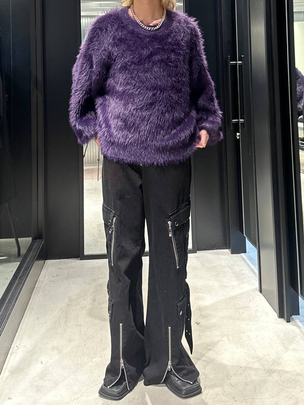 パープル系のニット/セーター、ブラック系のデニムパンツ、シルバー系のネックレスを着用したメンズの秋コーディネートの4枚目の写真