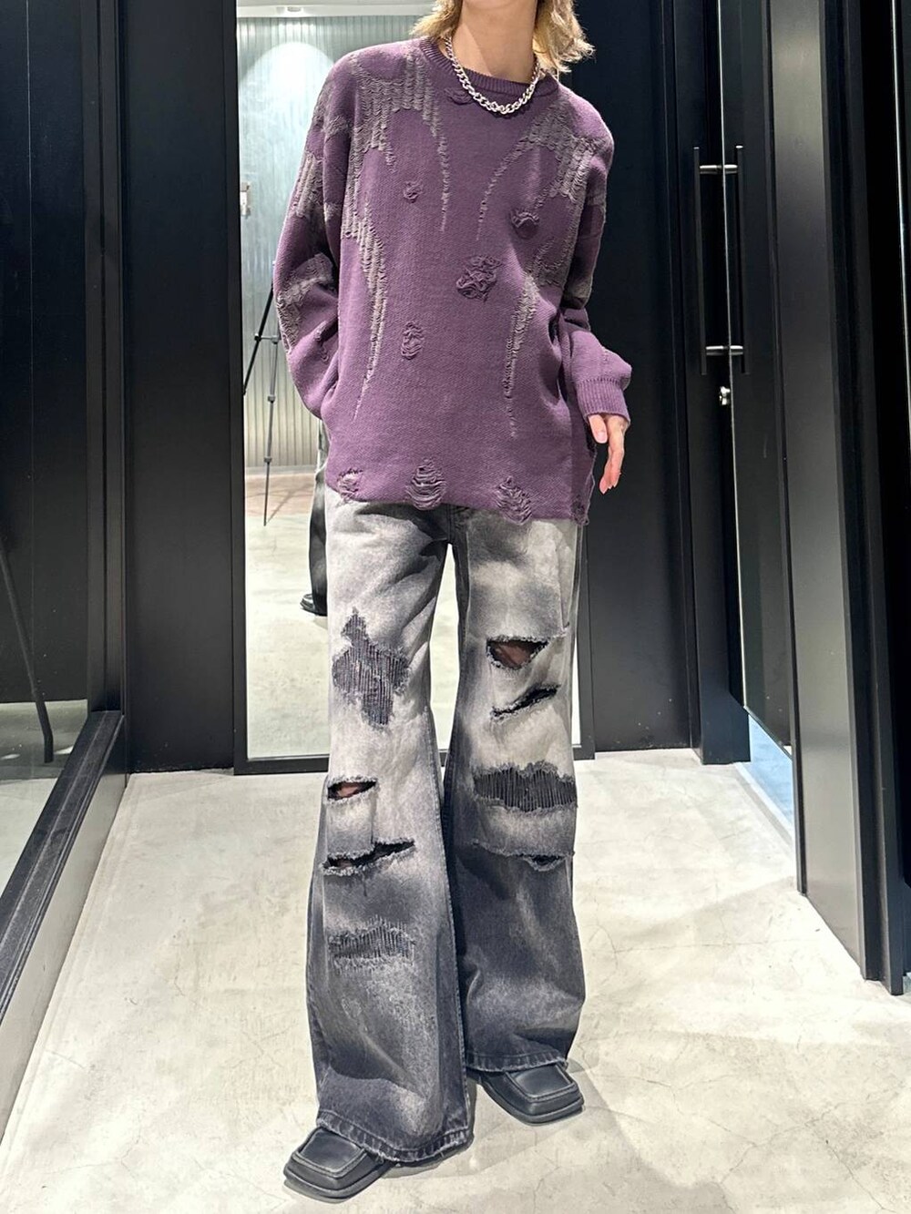 ブラック系のデニムパンツ、パープル系のニット/セーター、ブラック系のキャップを着用したメンズの秋コーディネートの3枚目の写真