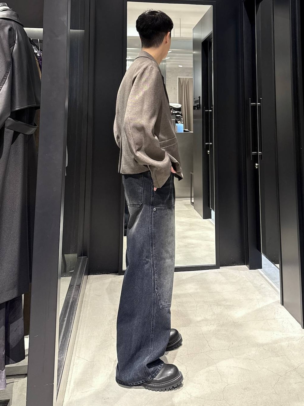 ブラック系のブーツ、ブルー系のデニムパンツ、ブラウン系のテーラードジャケットを着用したメンズの秋コーディネートの2枚目の写真