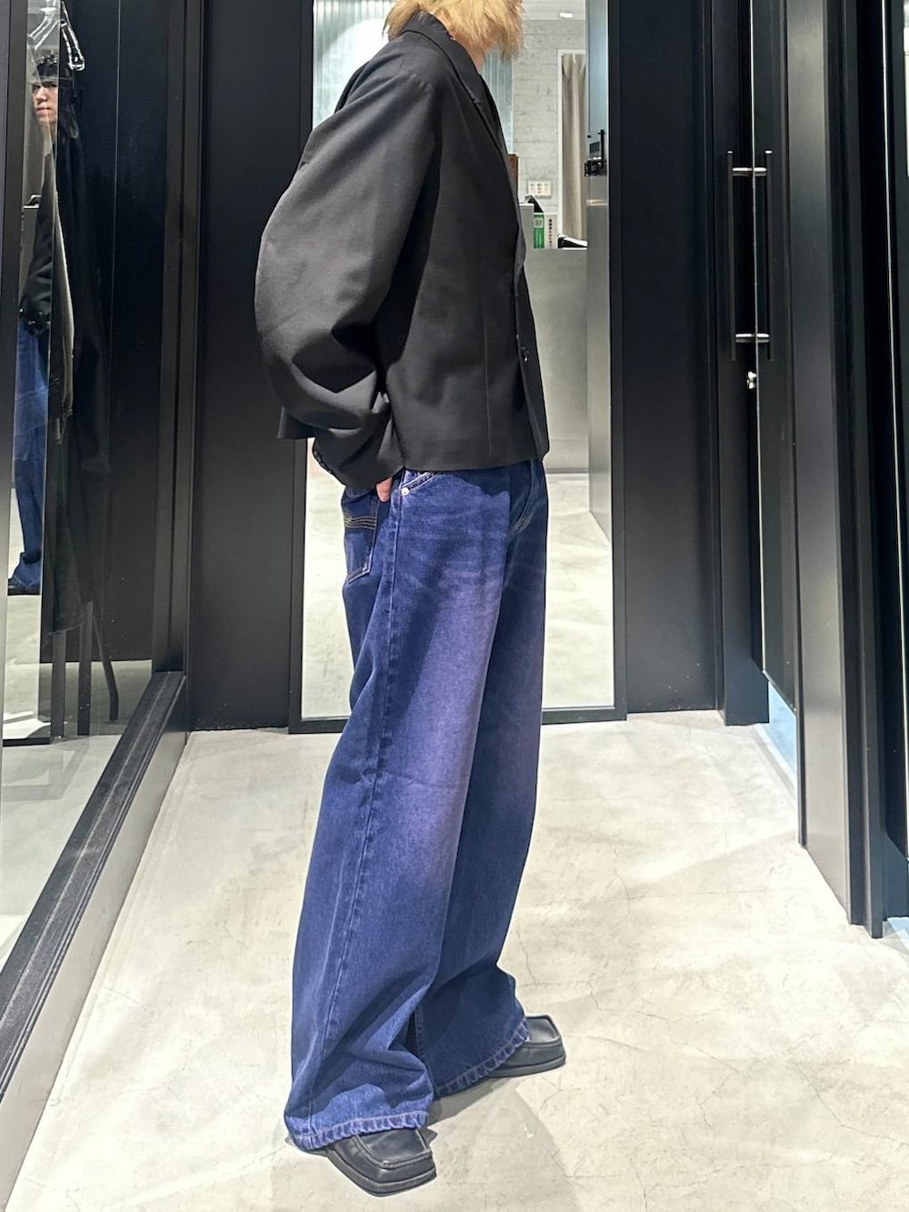 パープル系のデニムパンツ、ブラック系のテーラードジャケット、シルバー系のネックレスを着用したメンズの秋コーディネートの2枚目の写真