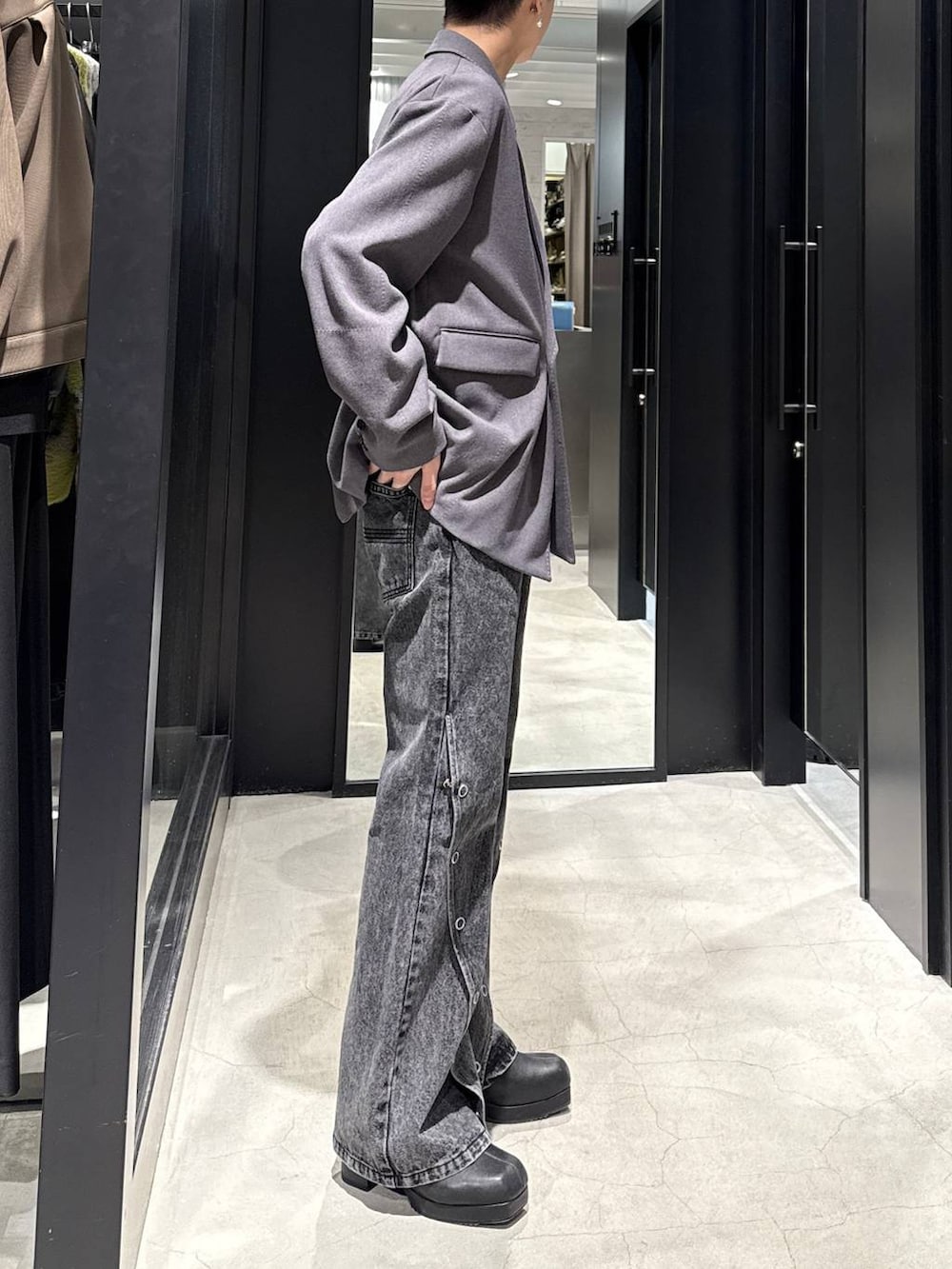 ブラック系のブーツ、グレー系のテーラードジャケット、ブラック系のデニムパンツを着用したメンズの冬コーディネートの2枚目の写真