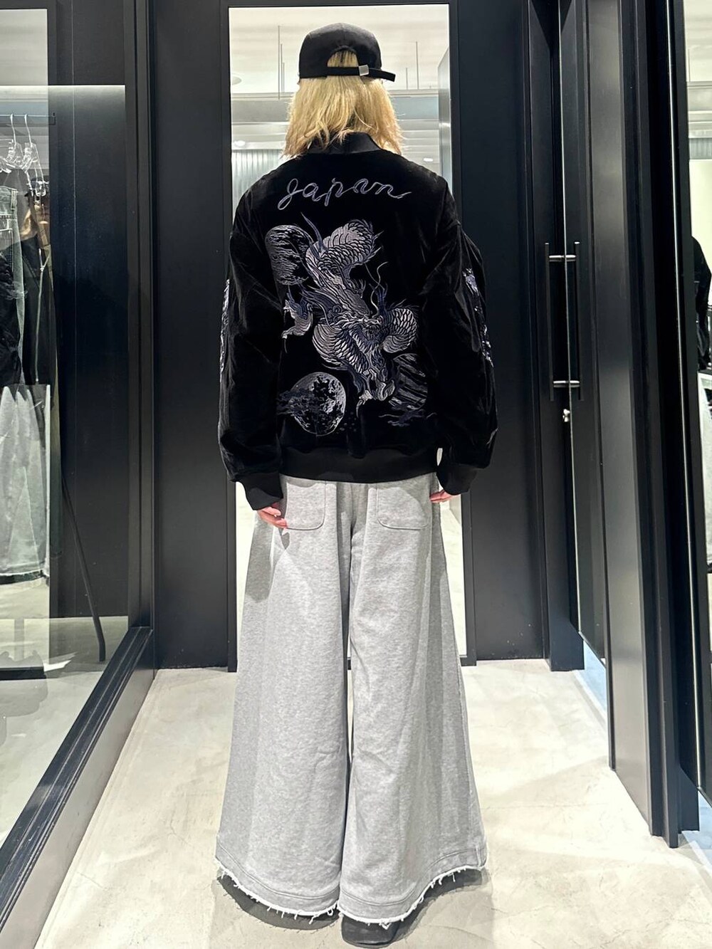 グレー系のスウェットパンツ、ブラック系のブルゾン、ブラック系のキャップを着用したメンズの秋コーディネートの3枚目の写真