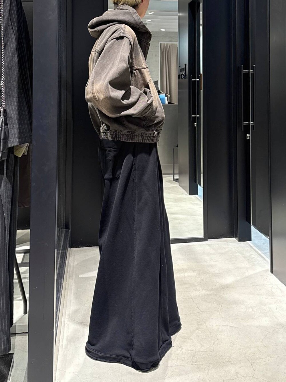 ブラック系のTシャツ/カットソー、ブラック系のスウェットパンツ、ブラウン系のブルゾンを着用したメンズの冬コーディネートの2枚目の写真