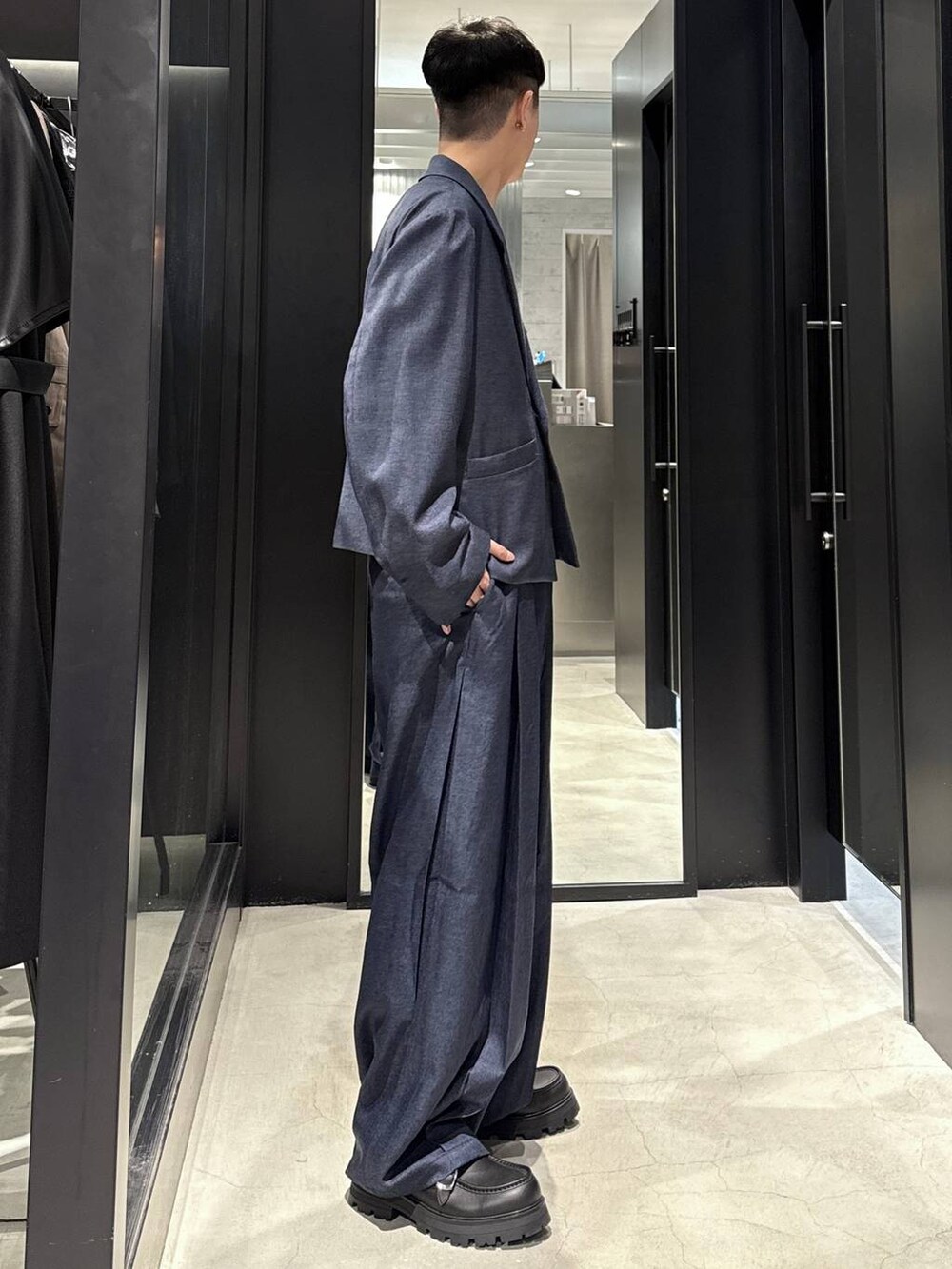 ブルー系のスラックス、ブラック系のドレスシューズ、ブルー系のテーラードジャケットを着用したメンズの秋コーディネートの2枚目の写真