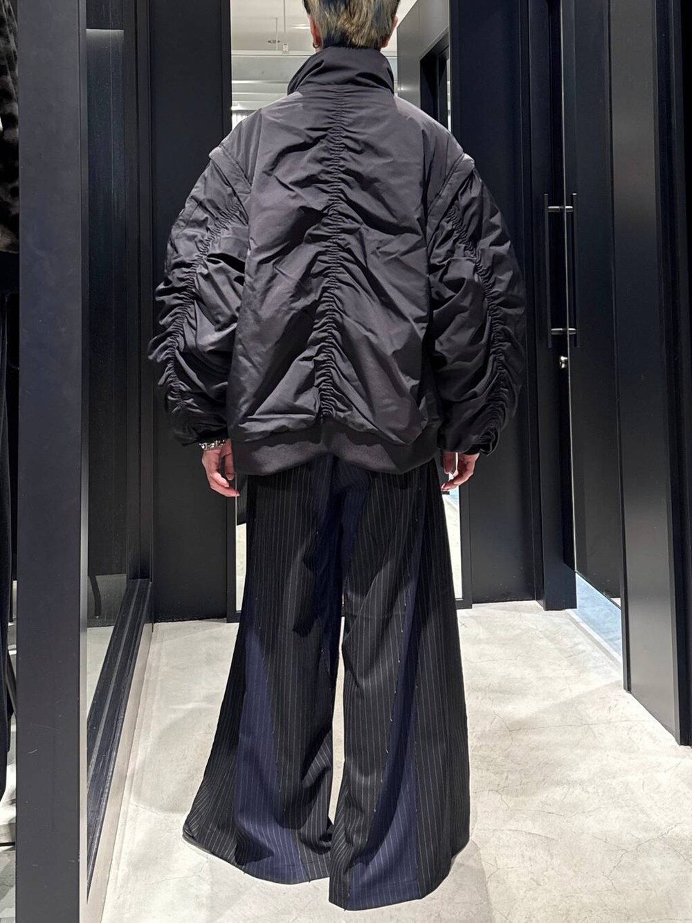 ブラック系のブルゾン、ブラック系のその他パンツ、シルバー系のネックレスを着用したメンズの冬コーディネートの3枚目の写真