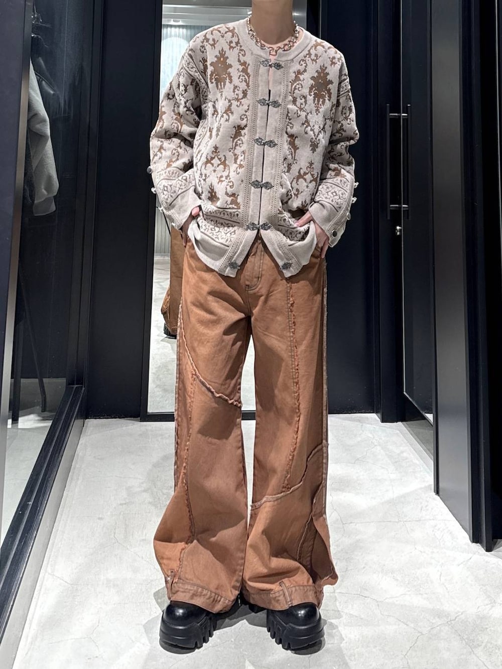 ブラック系のカーディガン/ボレロ、オレンジ系のデニムパンツ、シルバー系のネックレスを着用したメンズの冬コーディネートの4枚目の写真