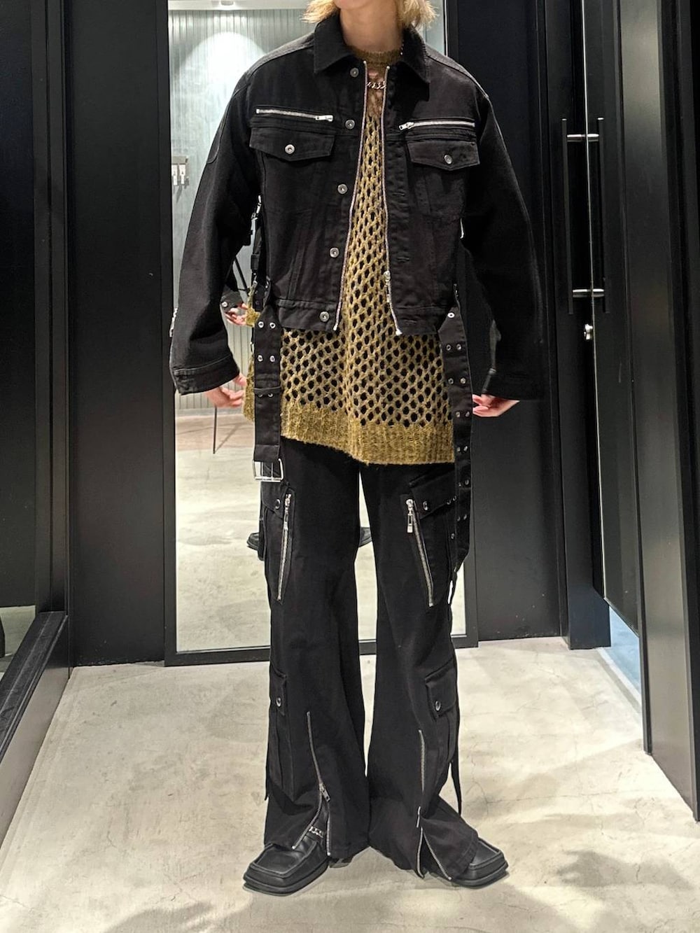 ブラック系のデニムパンツ、イエロー系のニット/セーター、ブラック系のデニムジャケットを着用したメンズの秋コーディネートの5枚目の写真