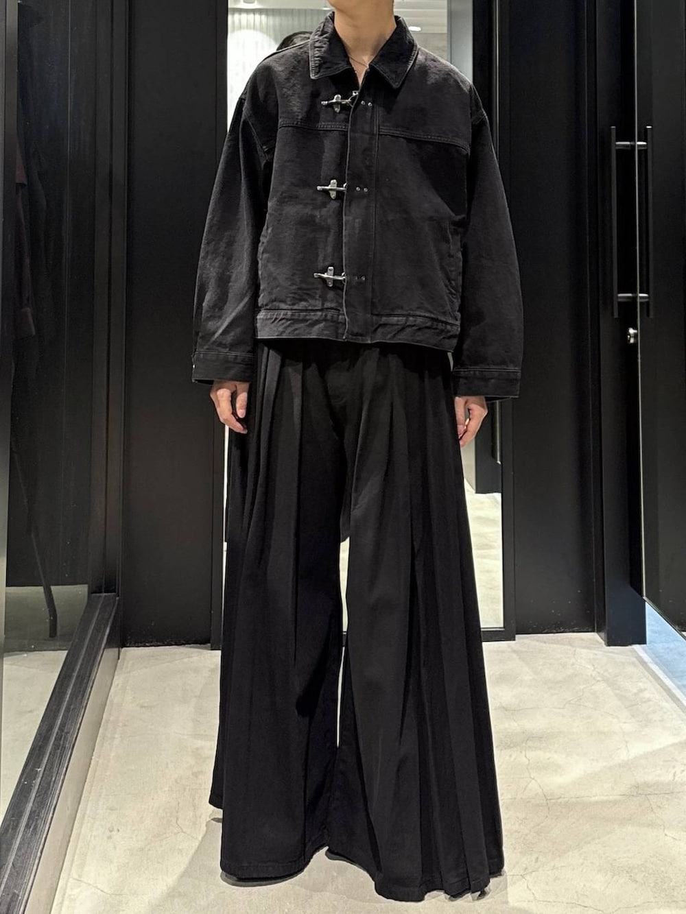 ホワイト系のTシャツ/カットソー、ブラック系のデニムパンツ、ブラック系のブーツを着用したメンズの秋コーディネートの4枚目の写真