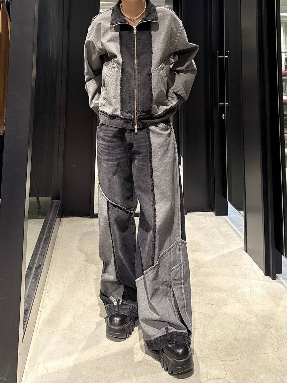 ブラック系のデニムパンツ、ブラック系のブルゾン、ホワイト系のネックレスを着用したメンズの冬コーディネートの4枚目の写真