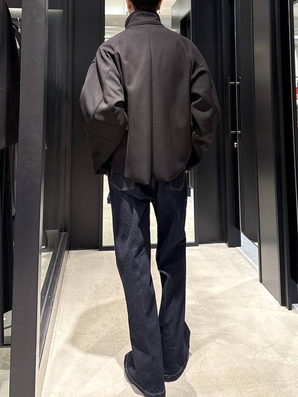 ブラック系のブーツ、ブルー系のデニムパンツ、ブラック系のブルゾンを着用したメンズの冬コーディネートの3枚目の写真