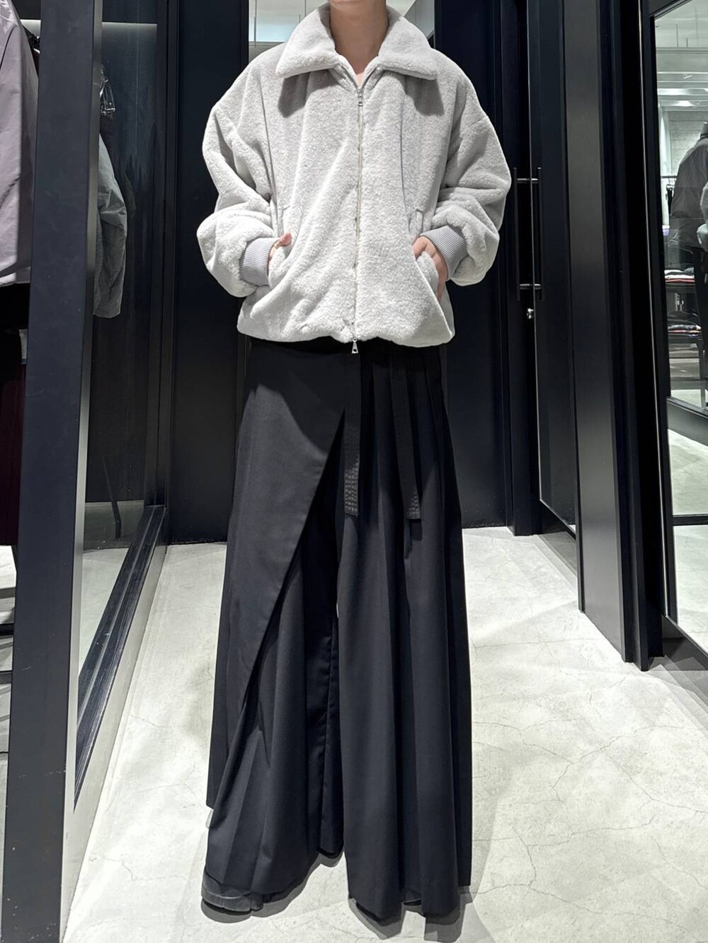 グレー系のブルゾン、ブラック系のスラックスを着用したメンズの冬コーディネートの4枚目の写真