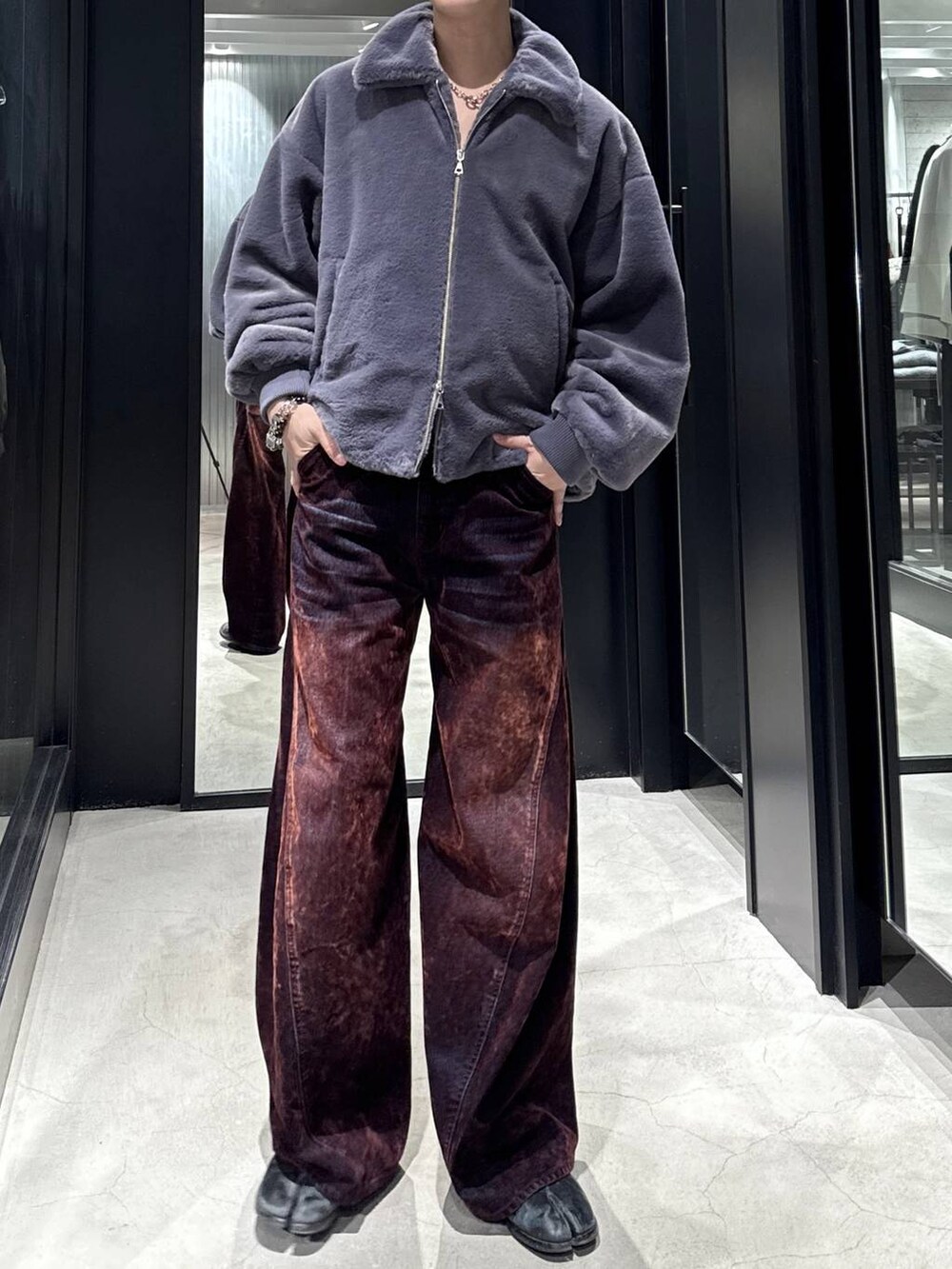 パープル系のブルゾン、レッド系のデニムパンツを着用したメンズの秋コーディネートの4枚目の写真