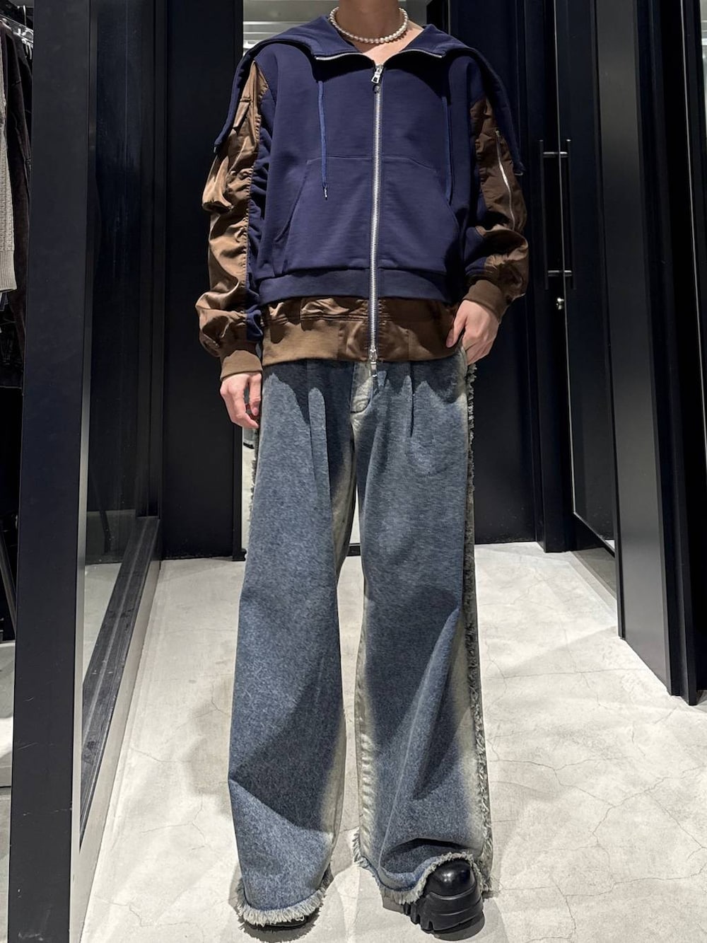 ブルー系のデニムパンツ、ブルー系のパーカー、ホワイト系のネックレスを着用したメンズの冬コーディネートの3枚目の写真