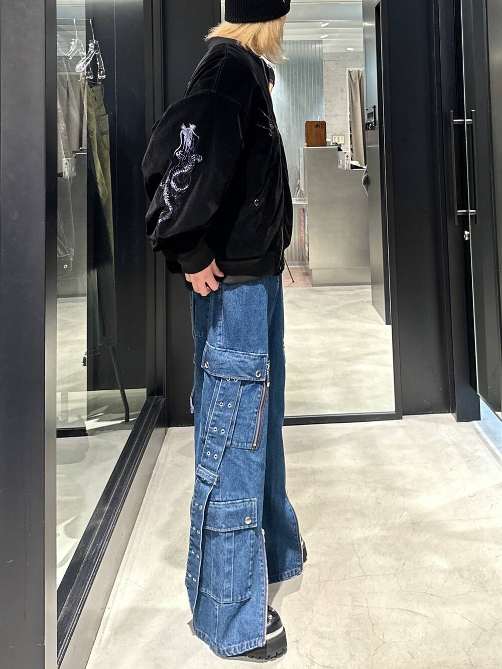 ブラック系のブルゾン、ブラック系のその他シューズ、ブルー系のデニムパンツを着用したメンズの秋コーディネートの3枚目の写真