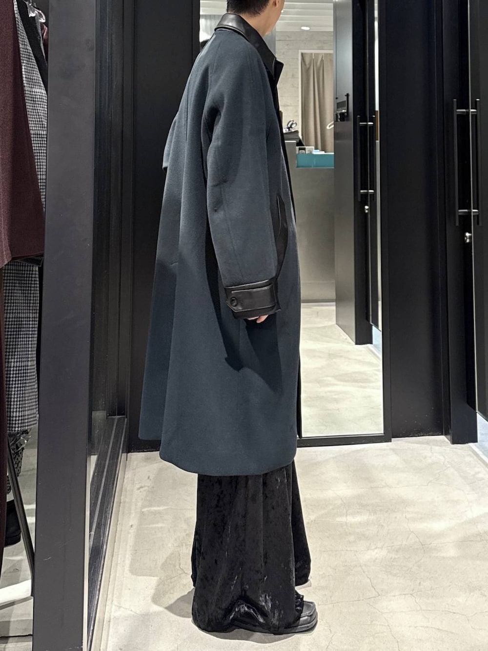 グリーン系のステンカラーコート、ブラック系のその他パンツ、ブラック系のスウェットを着用したメンズの秋コーディネートの2枚目の写真