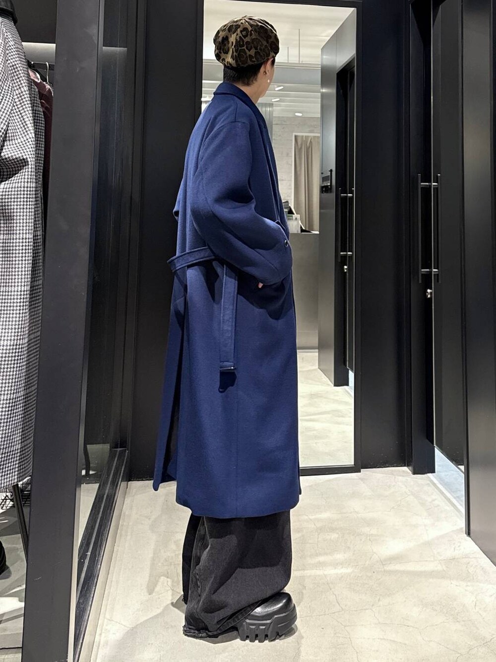 ブラック系のデニムパンツ、ブラック系のカーディガン/ボレロ、ブルー系のチェスターコートを着用したメンズの秋コーディネートの2枚目の写真