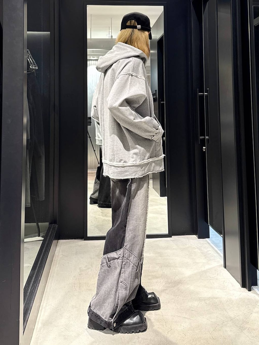 ブラック系のデニムパンツ、グレー系のパーカー、ブラック系のキャップを着用したメンズの秋コーディネートの2枚目の写真
