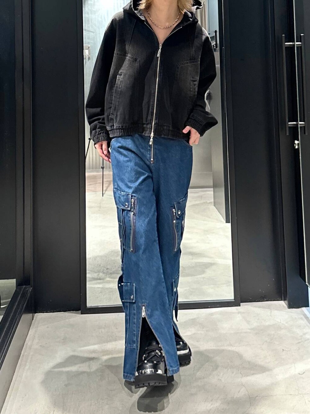 ブラック系のブルゾン、ブラック系のその他シューズ、ブルー系のデニムパンツを着用したメンズの秋コーディネートの3枚目の写真