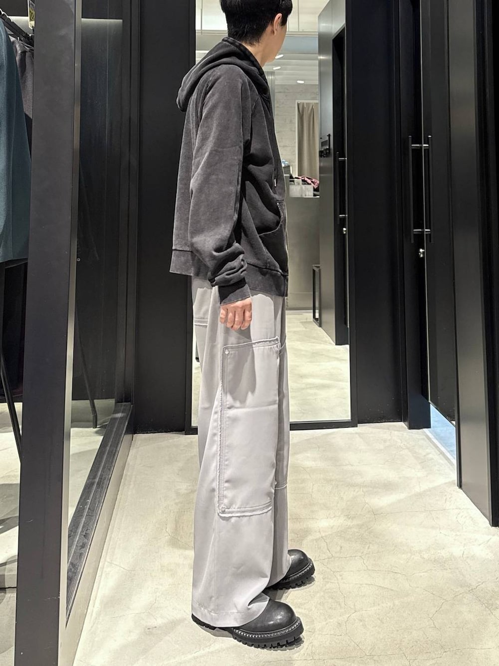 ブラック系のパーカー、ブラック系のブーツ、シルバー系のネックレスを着用したメンズの秋コーディネートの2枚目の写真