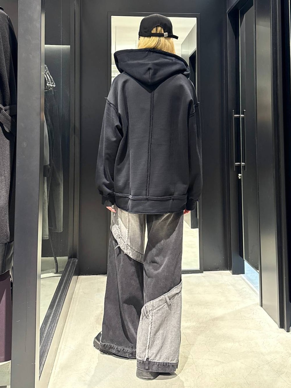 ブラック系のデニムパンツ、ブラック系のパーカー、ブラック系のキャップを着用したメンズの秋コーディネートの3枚目の写真