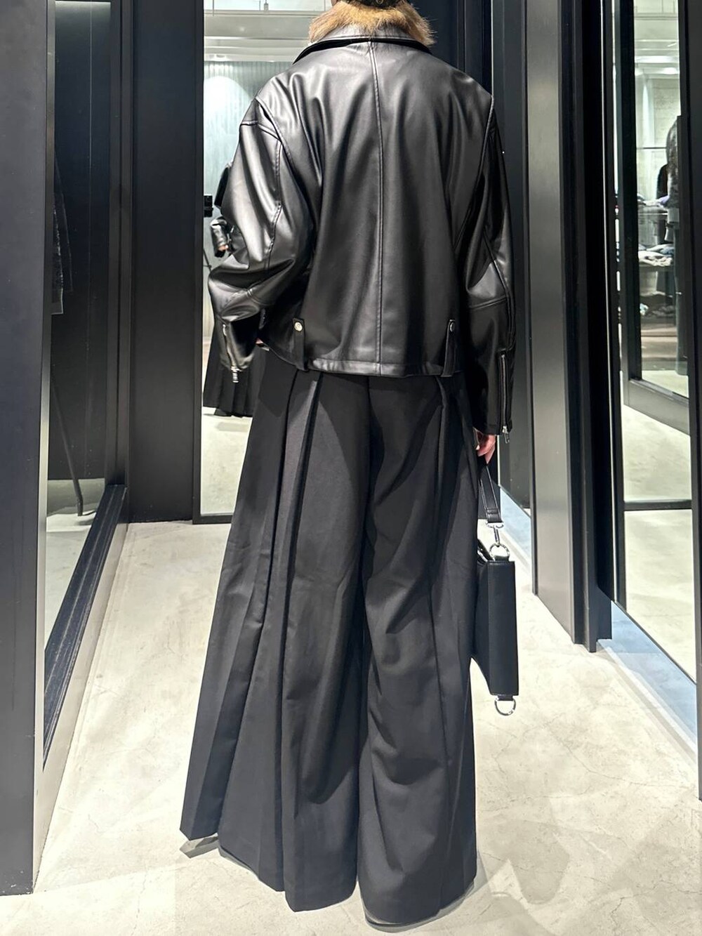 ブラック系のその他パンツ、ブラック系のショルダーバッグ、ブラック系のライダースジャケットを着用したメンズの秋コーディネートの2枚目の写真