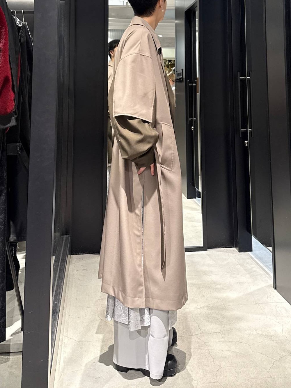 ブラック系のブーツ、ベージュ系のトレンチコート、グレー系のその他パンツを着用したメンズの冬コーディネートの2枚目の写真