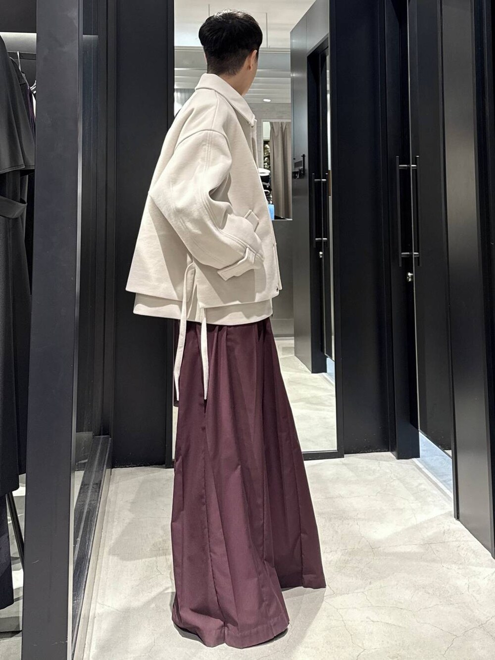 ホワイト系のブルゾン、ブラック系のブーツ、レッド系のその他パンツを着用したメンズの秋コーディネートの2枚目の写真