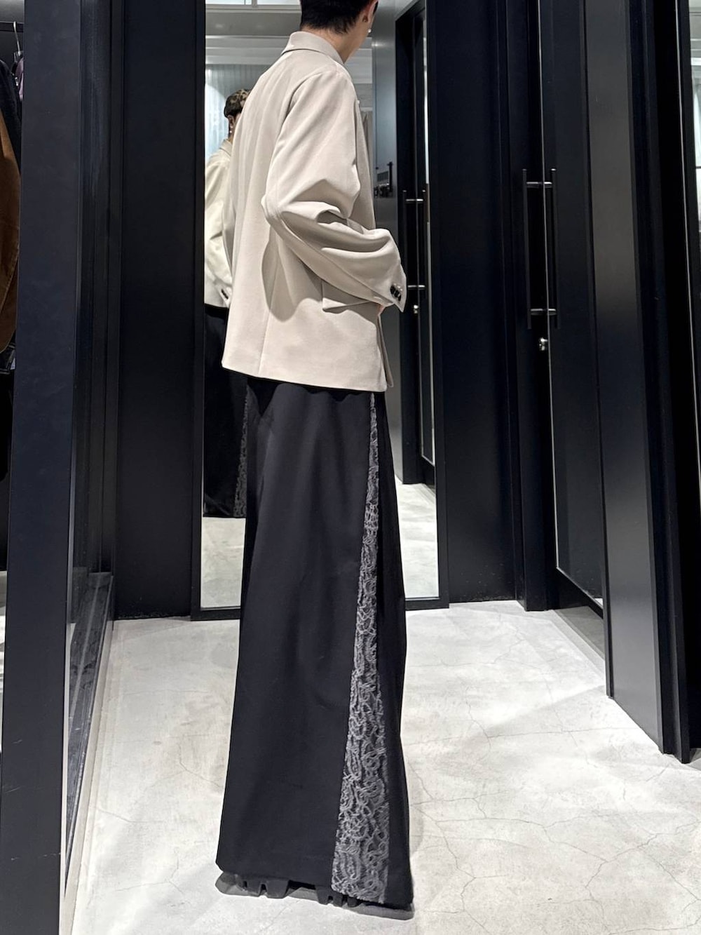 ベージュ系のテーラードジャケット、ブラック系のその他パンツ、ホワイト系のネックレスを着用したメンズの冬コーディネートの2枚目の写真