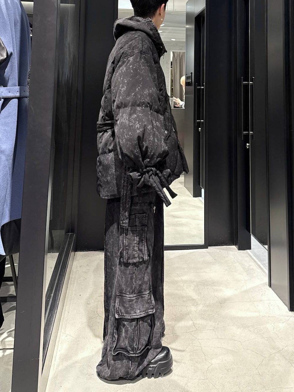 ブラック系のスウェットパンツ、ブラック系のパーカー、グレー系のダウンジャケット/コートを着用したメンズの冬コーディネートの2枚目の写真
