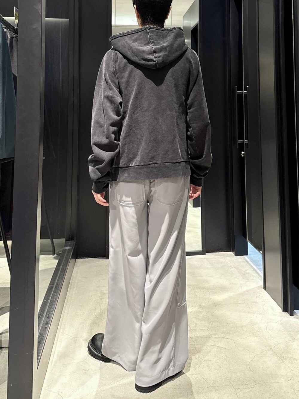 ブラック系のパーカー、ブラック系のブーツ、シルバー系のネックレスを着用したメンズの秋コーディネートの3枚目の写真