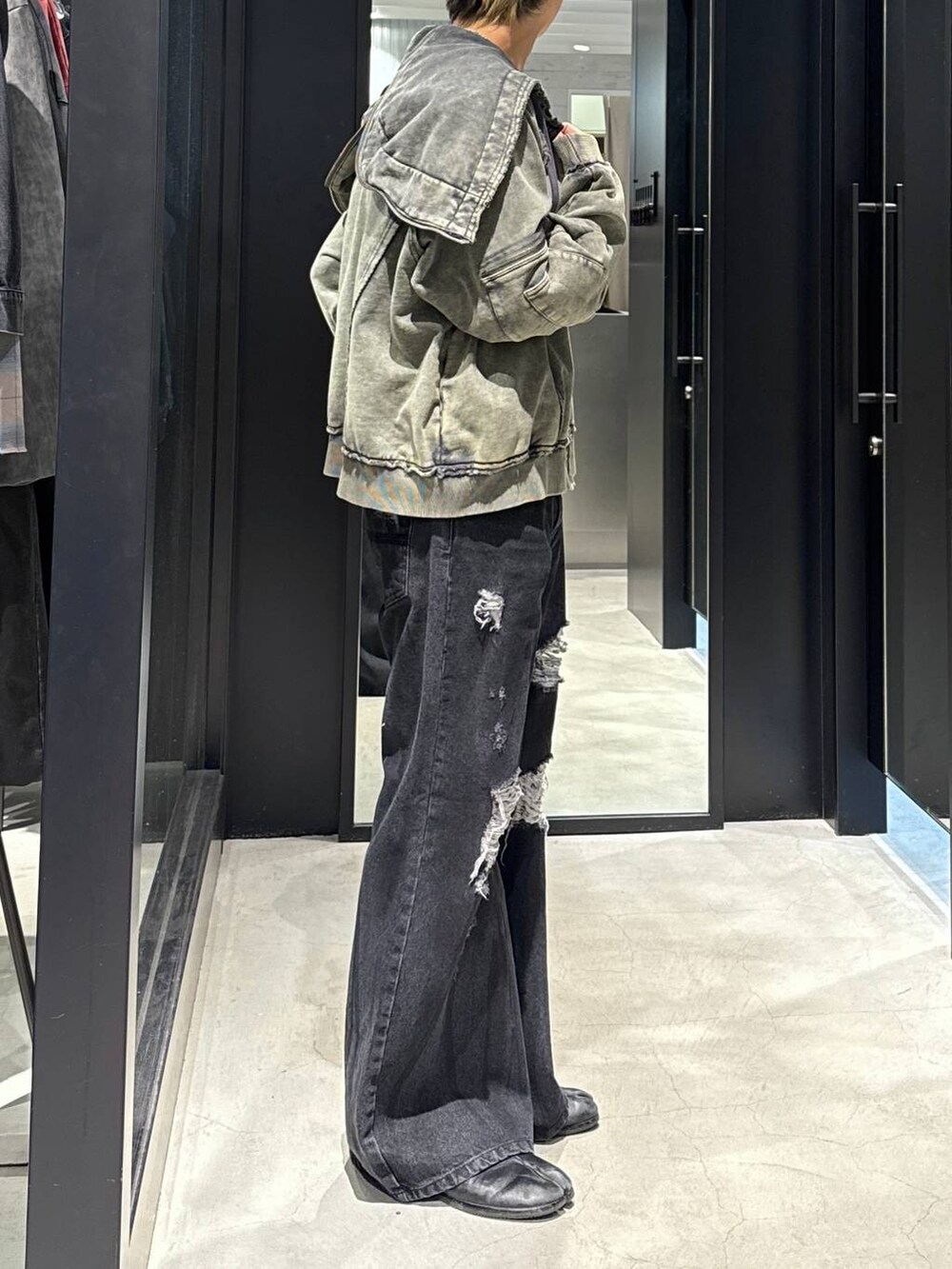 ブラック系のデニムパンツ、ブラック系のキャップ、シルバー系のネックレスを着用したメンズの冬コーディネートの2枚目の写真