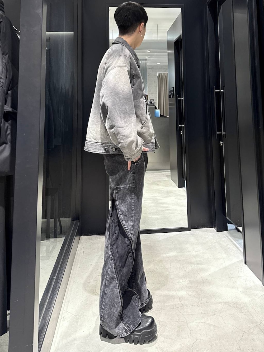 ブラック系のデニムパンツ、グレー系のブルゾン、シルバー系のネックレスを着用したメンズの冬コーディネートの2枚目の写真