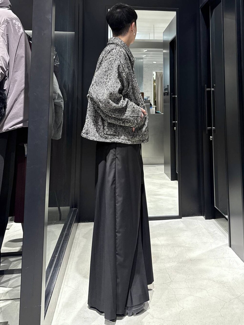 グレー系のブルゾン、ブラック系のスラックスを着用したメンズの冬コーディネートの2枚目の写真