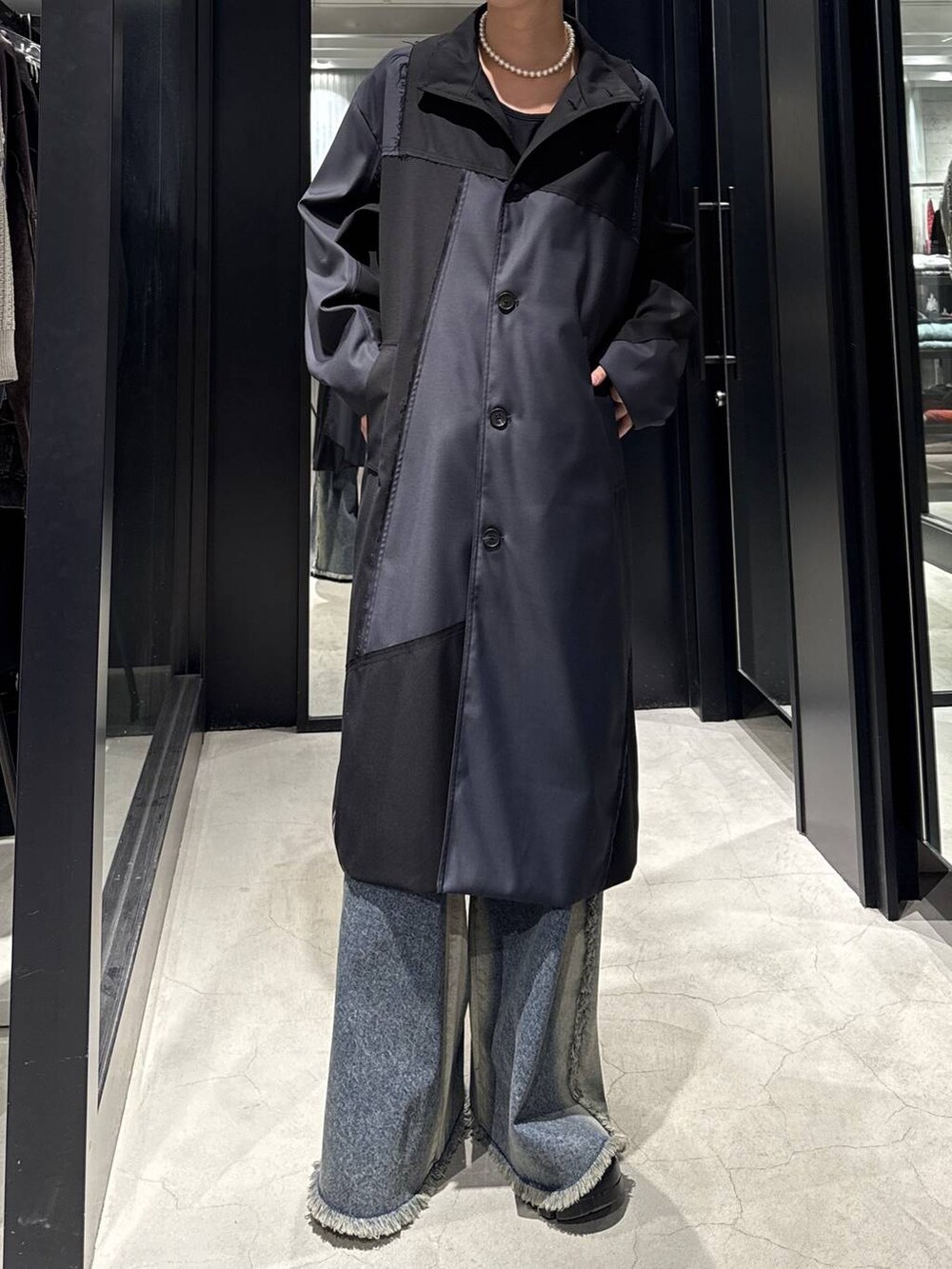 ブルー系のデニムパンツ、ブラック系のその他アウター、ホワイト系のネックレスを着用したメンズの冬コーディネートの3枚目の写真