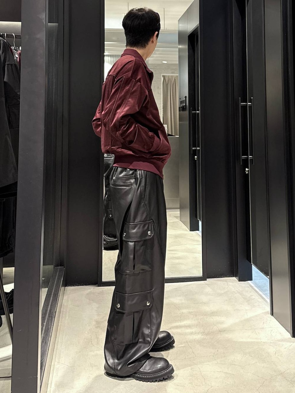 ブラック系のタンクトップ、ブラック系のカーゴパンツ、ブラック系のブーツを着用したメンズの秋コーディネートの2枚目の写真