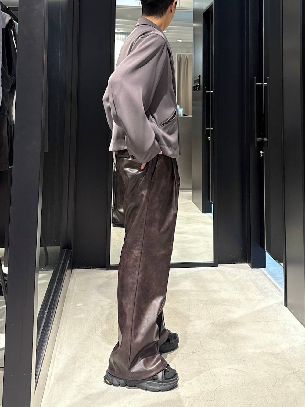 ブラック系のサンダル、ブラック系のタンクトップ、グレー系のテーラードジャケットを着用したメンズの夏コーディネートの4枚目の写真