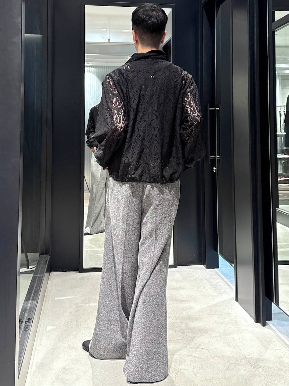 ブラック系のブルゾン、ブラック系のタンクトップ、ブラック系のスラックスを着用したメンズの夏コーディネートの2枚目の写真