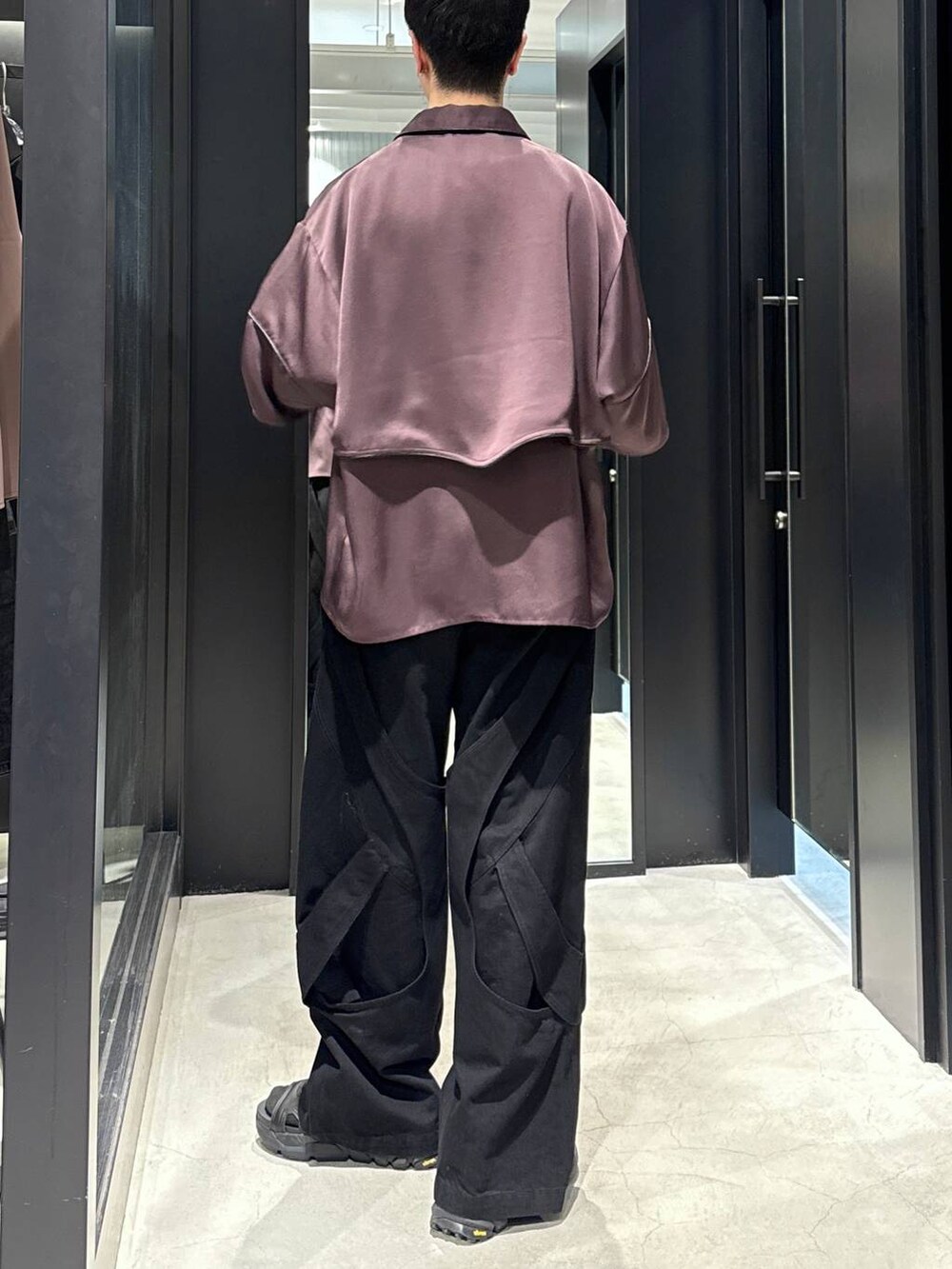 ブラック系のサンダル、ブラック系のデニムパンツ、ブラック系のタンクトップを着用したメンズの春コーディネートの3枚目の写真