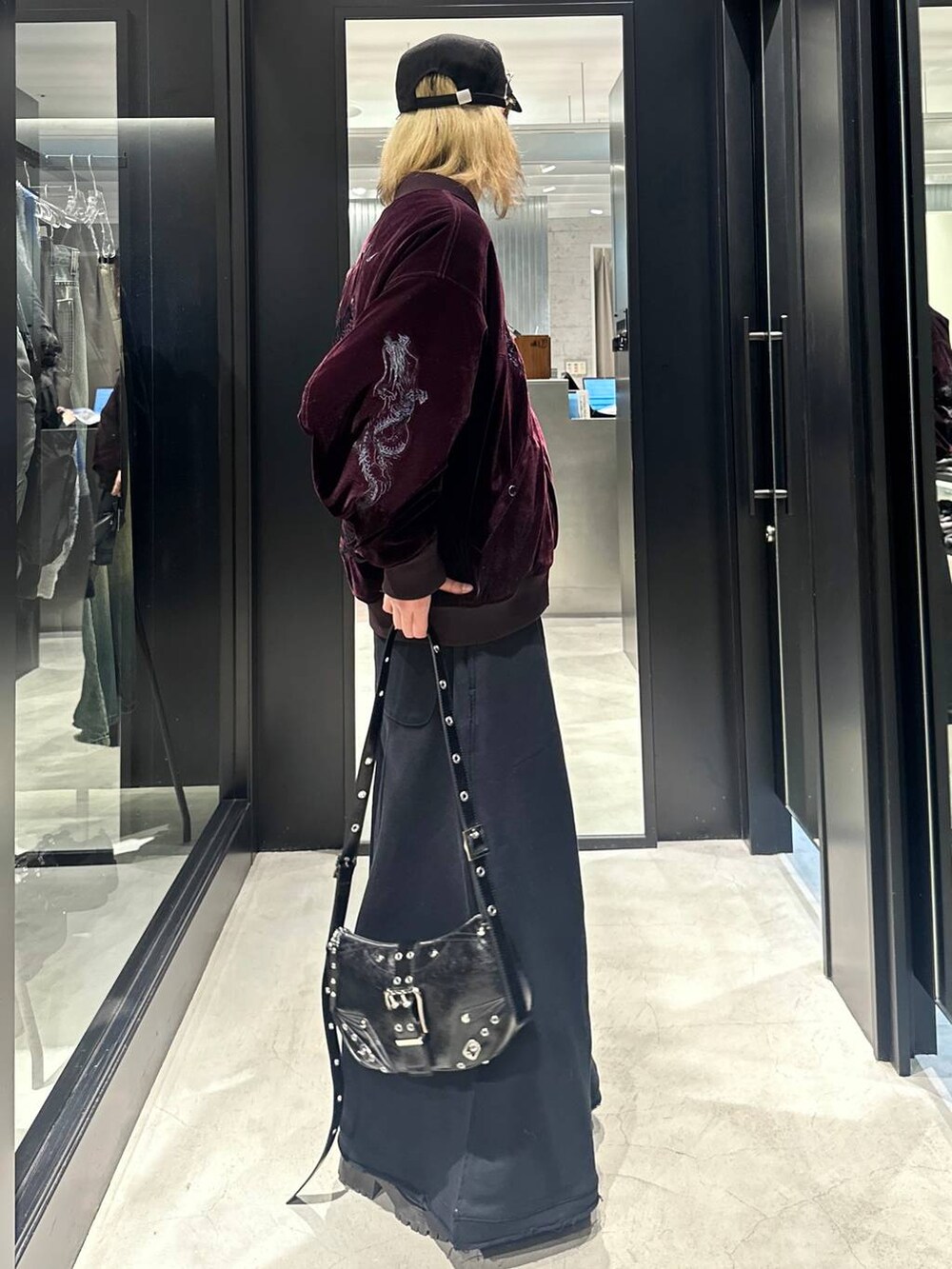 ブラック系のスウェットパンツ、ブラック系のショルダーバッグ、レッド系のブルゾンを着用したメンズの秋コーディネートの2枚目の写真