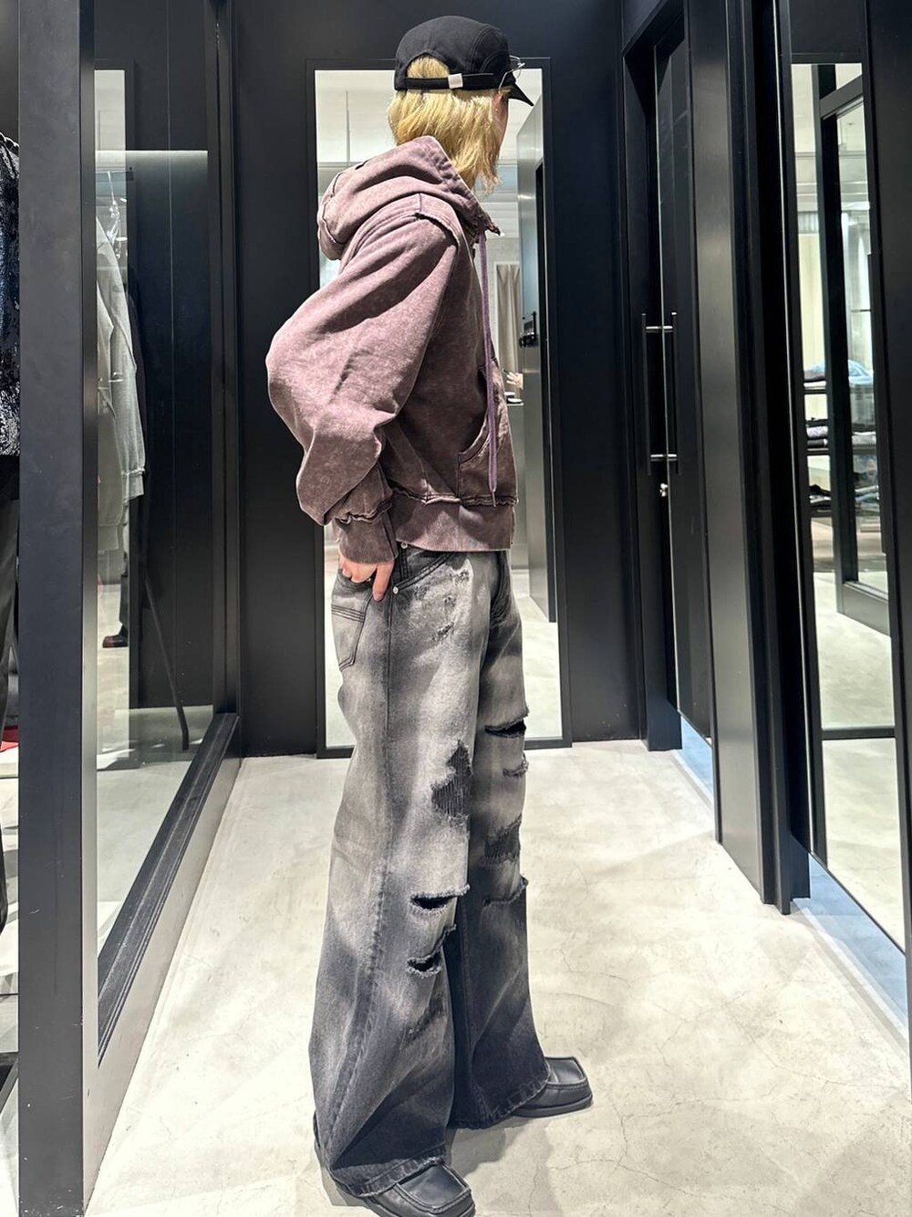 ブラック系のデニムパンツ、ブラウン系のパーカー、ブラック系のキャップを着用したメンズの秋コーディネートの2枚目の写真