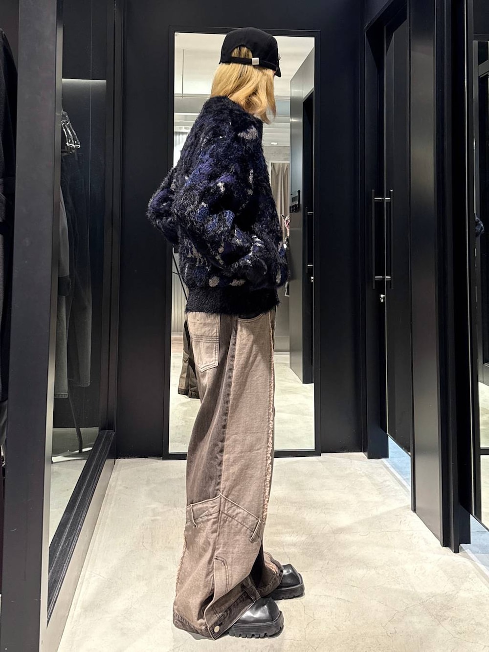 ブラウン系のデニムパンツ、ブラック系のニット/セーター、ブラック系のキャップを着用したメンズの秋コーディネートの3枚目の写真