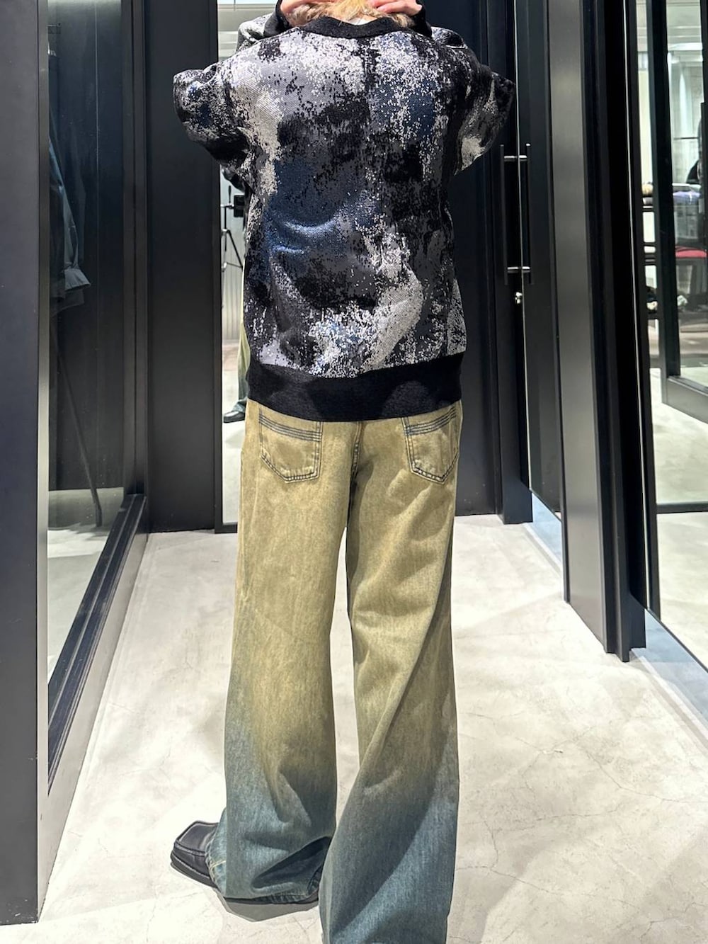 グリーン系のデニムパンツ、ブラック系のカーディガン/ボレロ、シルバー系のネックレスを着用したメンズの秋コーディネートの3枚目の写真