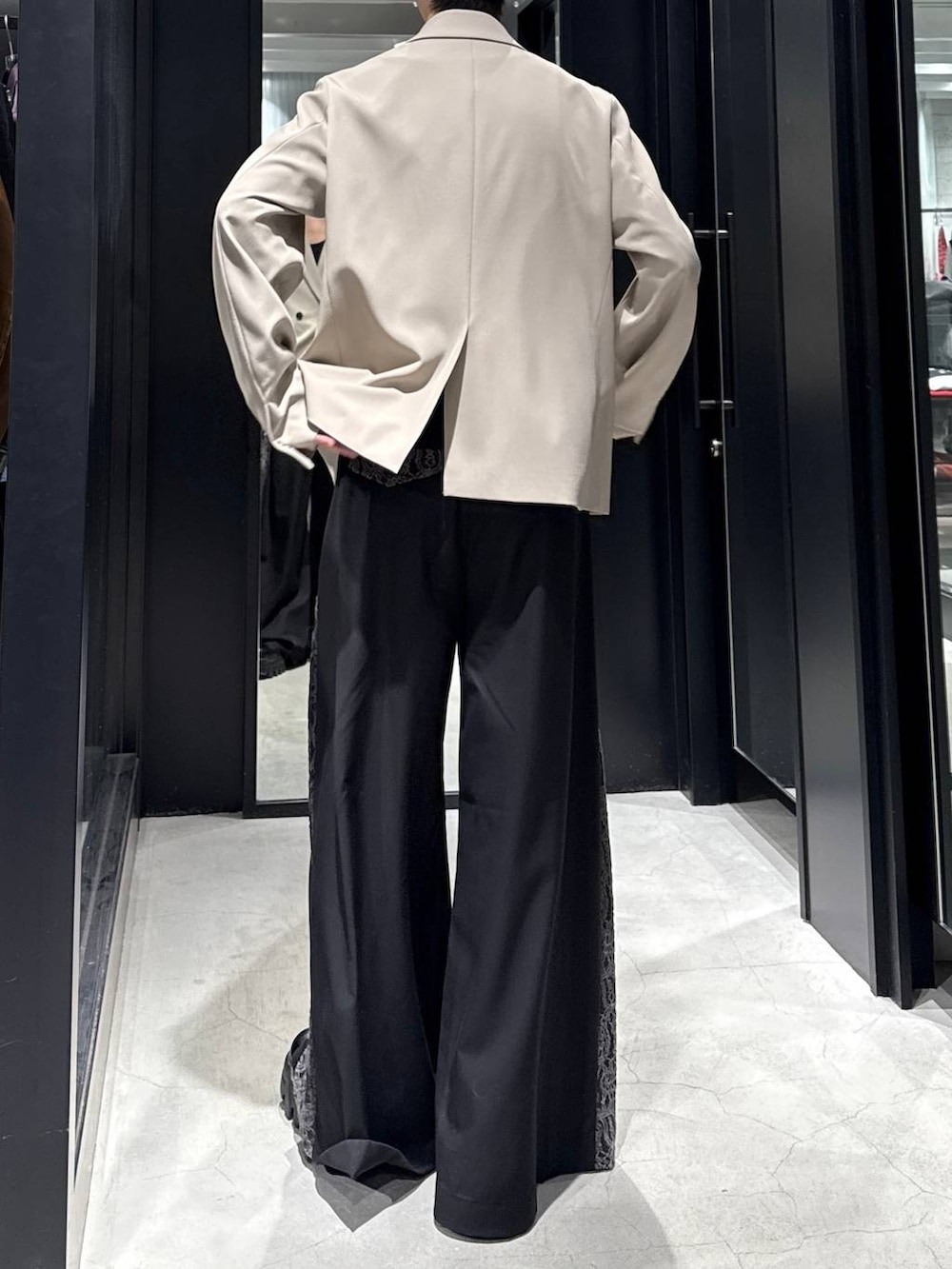 ベージュ系のテーラードジャケット、ブラック系のその他パンツ、ホワイト系のネックレスを着用したメンズの冬コーディネートの3枚目の写真