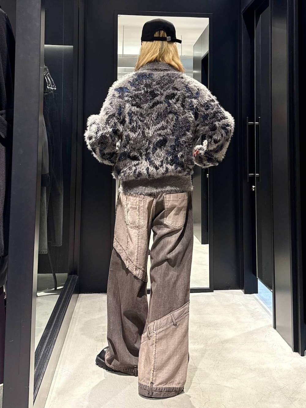 ブラウン系のデニムパンツ、グレー系のニット/セーター、ブラック系のキャップを着用したメンズの秋コーディネートの3枚目の写真