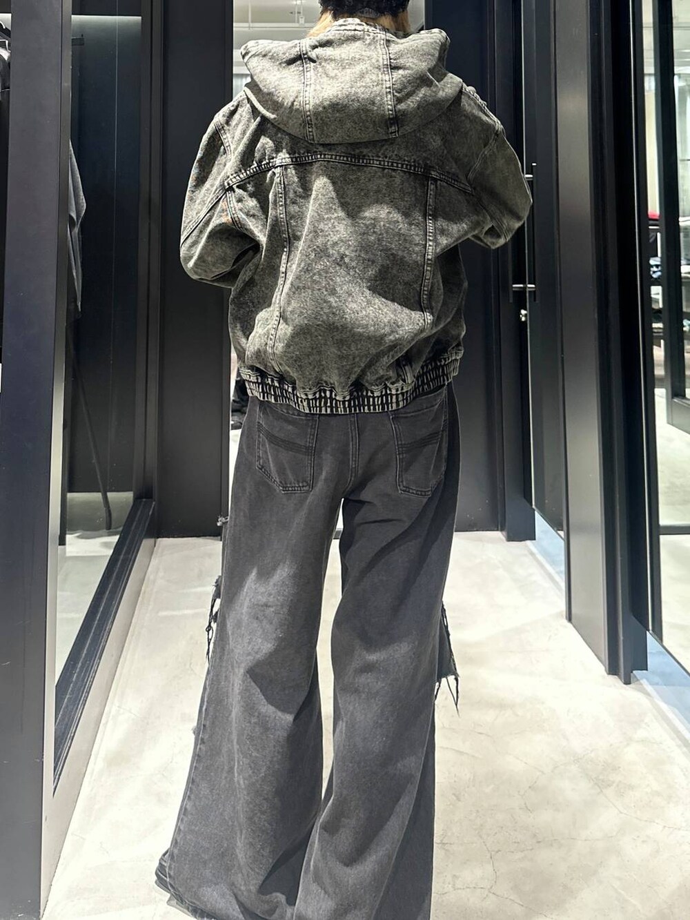 ブラック系のデニムパンツ、グリーン系のブルゾン、シルバー系のネックレスを着用したメンズの秋コーディネートの4枚目の写真